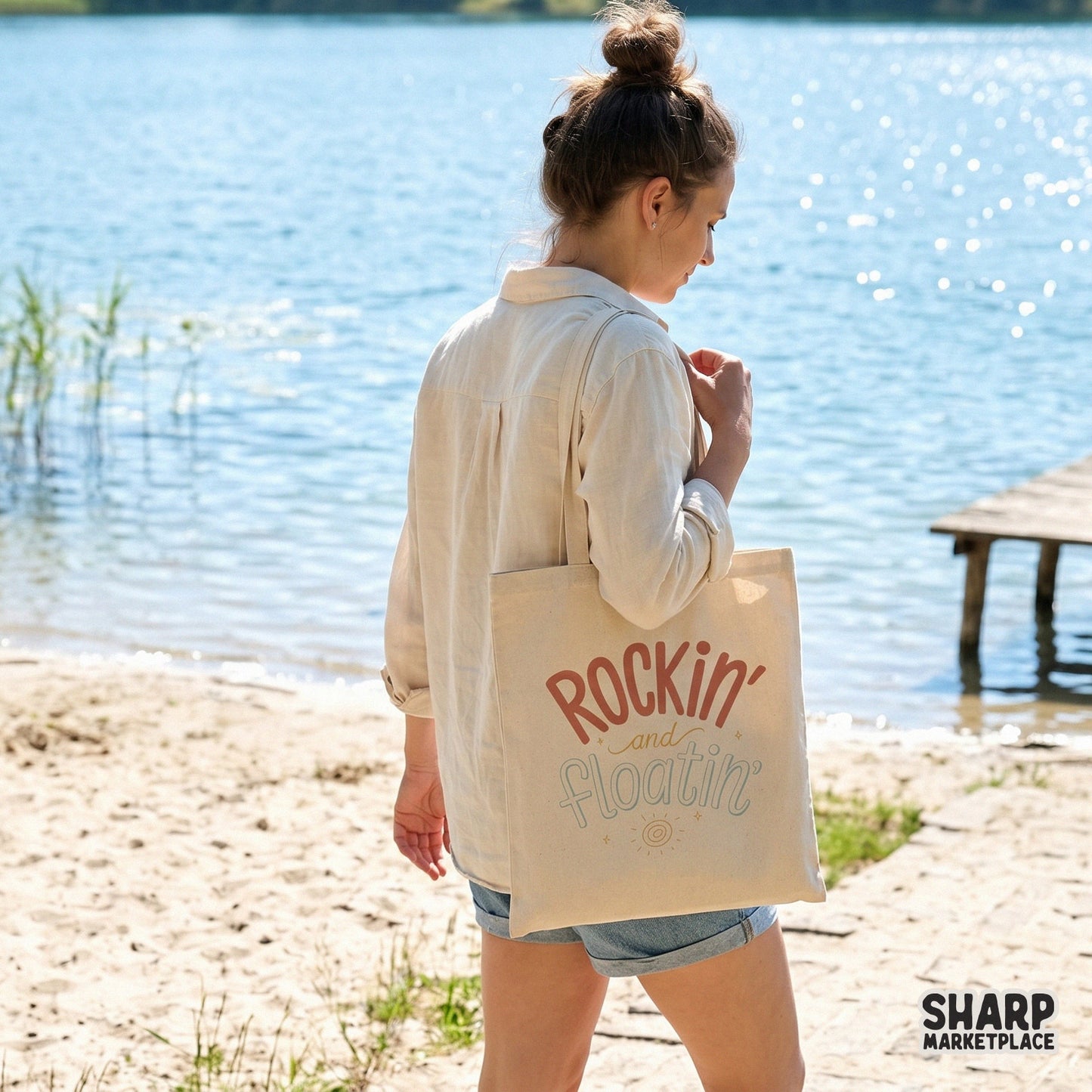 A tote bag mockup displaying the Rockin and Floatin retro summer design with earthy colors, perfect for lake life apparel and beach accessories.