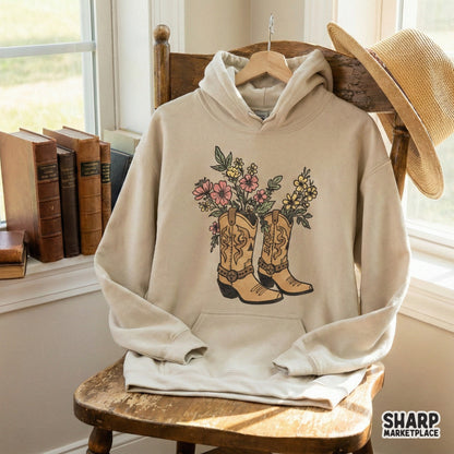 Digital western graphic of rustic cowboy boots overflowing with wildflowers in muted tones, perfect for custom tumblers, stickers, and country-themed decor.
