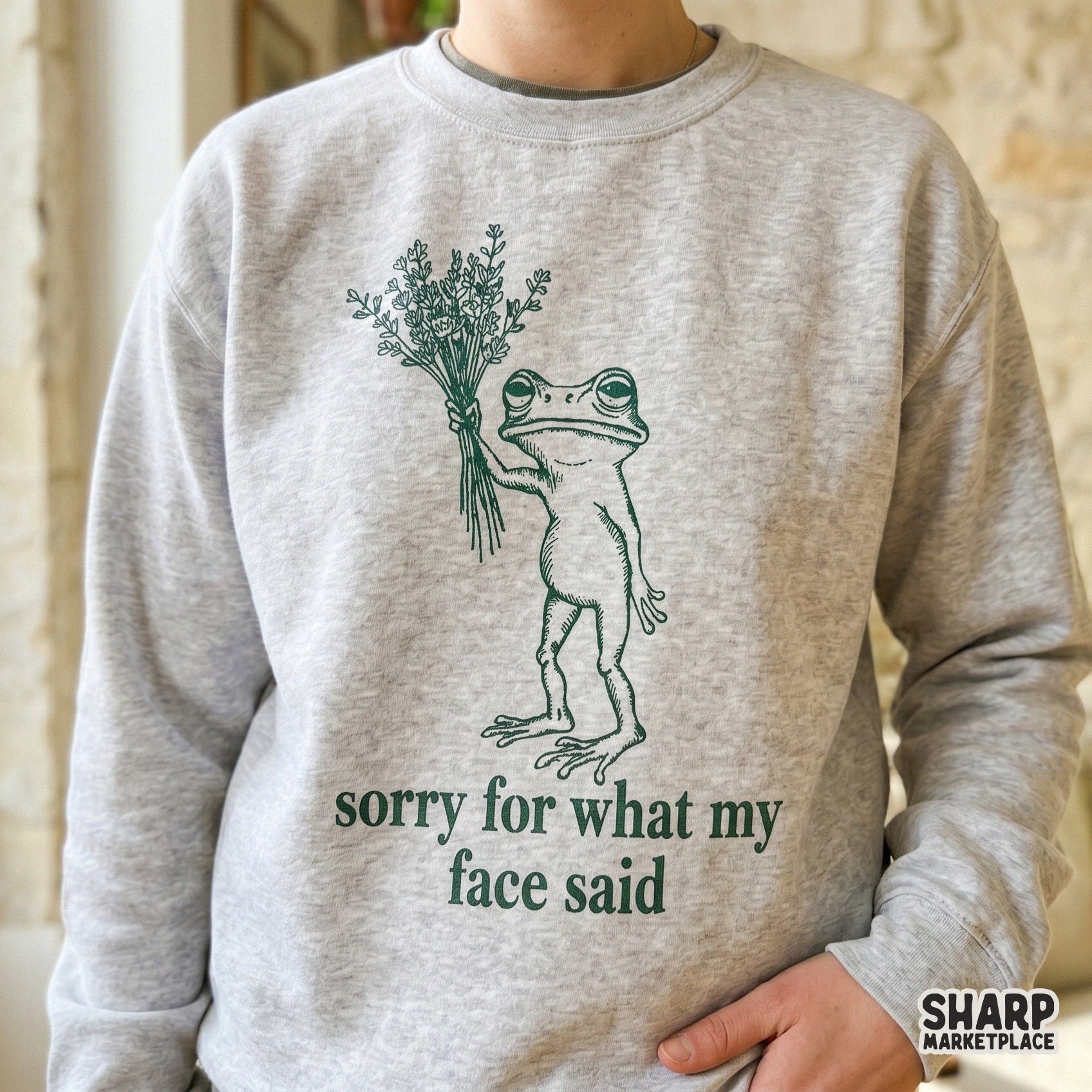 Whimsical frog graphic with a bouquet and the witty phrase sorry for what my face said, designed for print-on-demand apparel, tumblers, and DIY gifts.