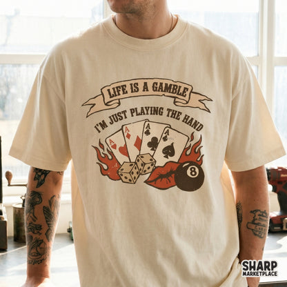 Vintage style sublimation graphic on a t-shirt showing a poker hand of four aces, dice, and an eight ball with the quote Life Is A Gamble I'm Just Playing The