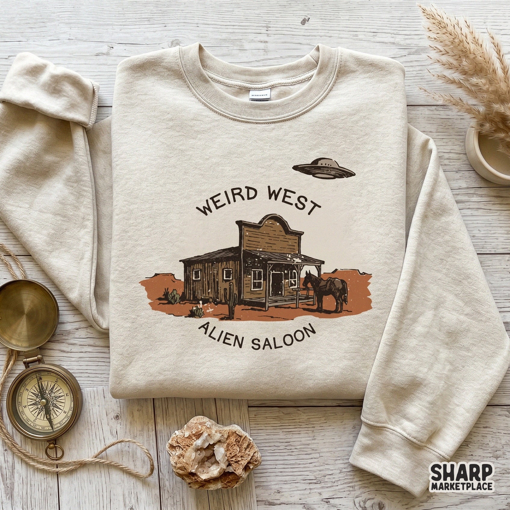 Digital sublimation design showing a hand-drawn desert scene with a saloon and an alien spacecraft, perfect for trendy western apparel and stickers.