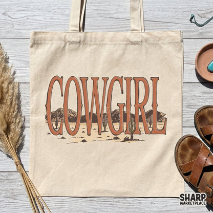 Boho western style Cowgirl text design with a detailed desert mountain and cactus landscape, ideal for t-shirt printing and sublimation.