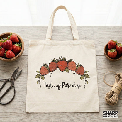 Cottagecore style strawberry design featuring five red berries and green vines with the text Taste of Paradise, shown printed on a canvas tote bag.
