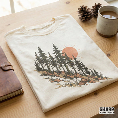 Vintage-style mountain pine tree illustration with a warm sun, featured as a digital design on a cream-colored t-shirt for outdoor enthusiasts.