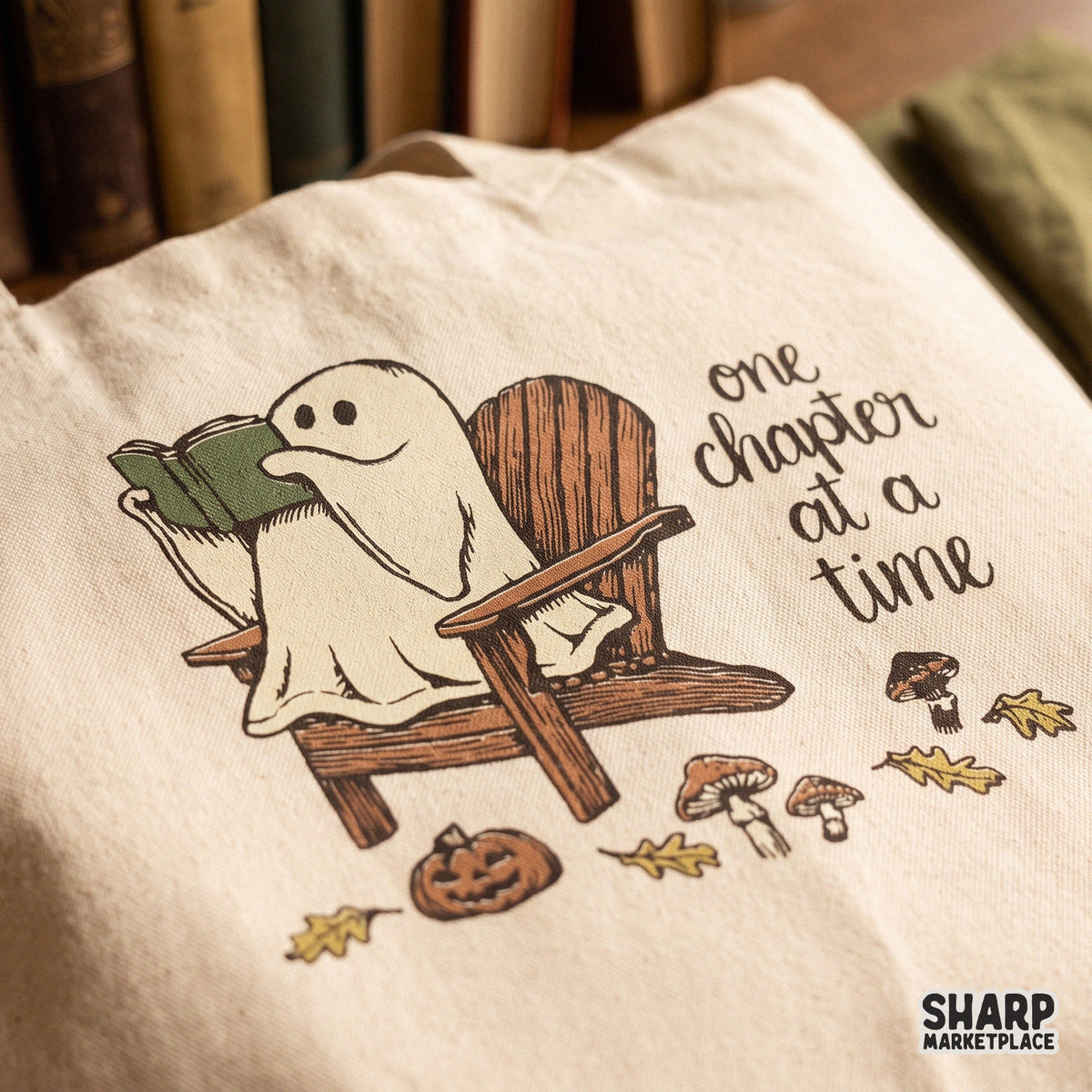 Cute ghost reading a book fall graphic in a cozy spooky season style perfect for bookworm t-shirts and stickers