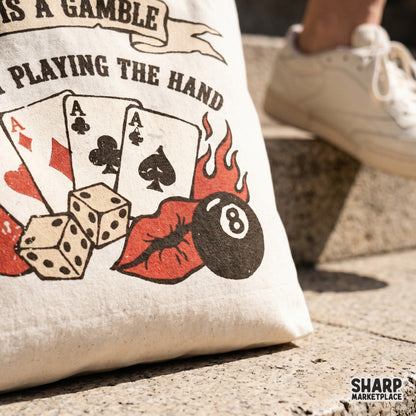 Distressed poker design for apparel featuring four playing cards, flaming dice, and a black eight ball with bold typography reading Life Is A Gamble.