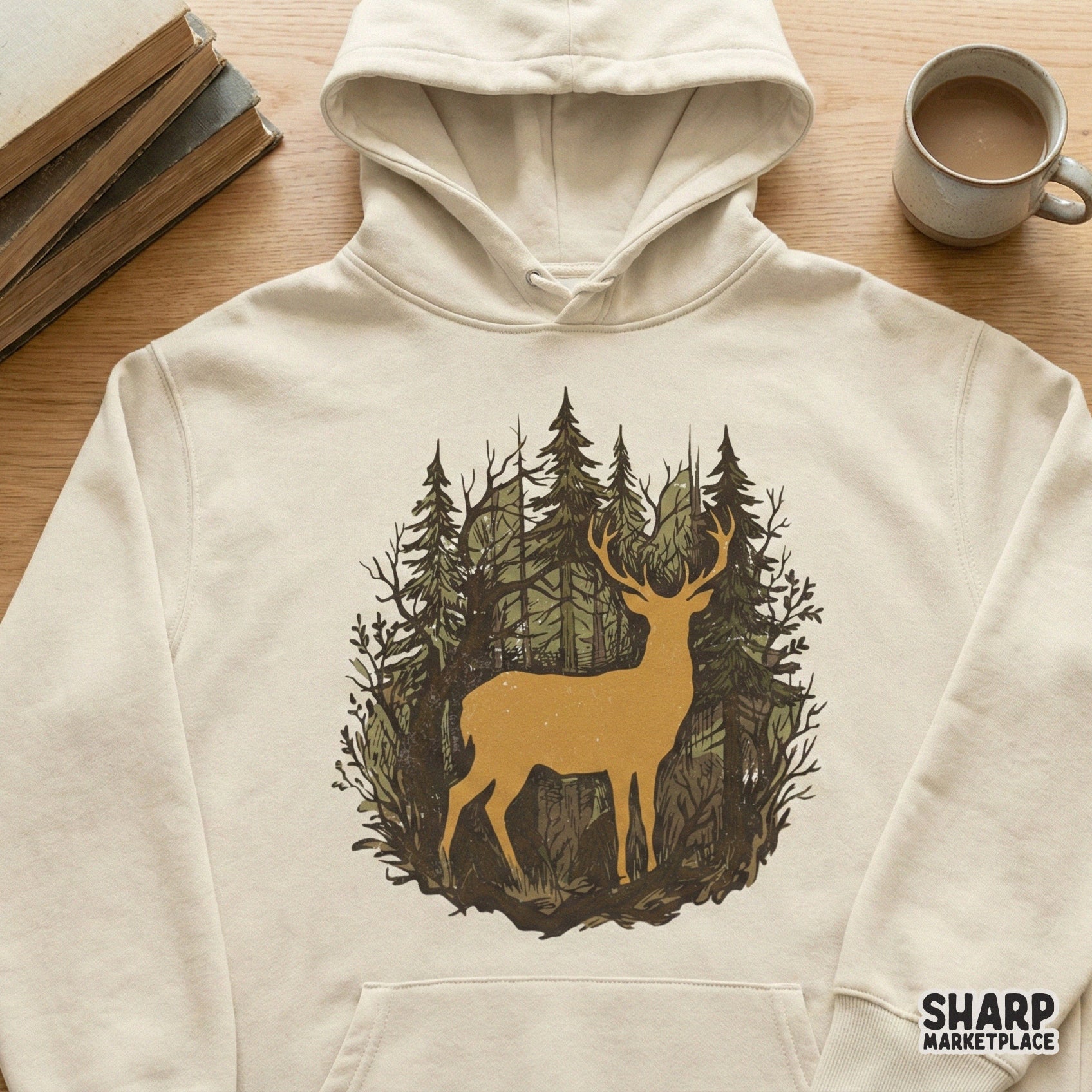 Vintage-style deer forest graphic printed on a cream-colored hoodie, featuring a majestic stag silhouette amidst hand-drawn pine trees and branches.