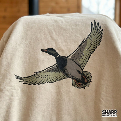 Retro-inspired waterfowl design featuring a mallard duck gliding through the air, ideal for creating custom hunting-themed stickers or wall art prints.