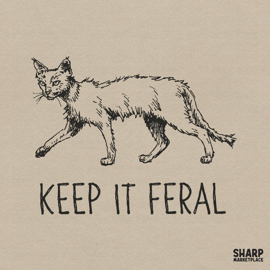 Hand-drawn sketch of a scruffy, feral cat with a wild gaze and the text Keep It Feral in a bold, hand-lettered font for apparel or sublimation.