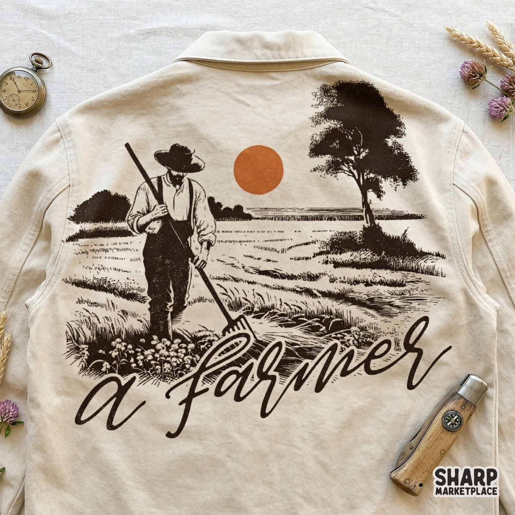 Rustic harvest scene digital design showing a farmer working in a field with a lone tree and orange sun, displayed on a neutral fabric background.