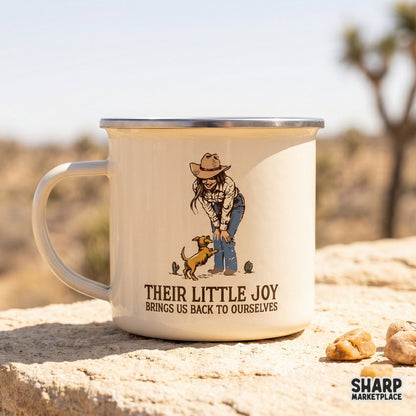 Cream-colored enamel mug featuring a western digital design of a cowgirl and her dog with the text Their Little Joy Brings Us Back To Ourselves.