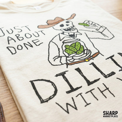Western-themed digital design of a skeleton cowboy eating a pickle with the funny quote Just About Done Dillin With Yall for custom apparel.