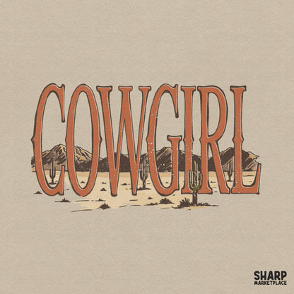 Retro western Cowgirl typography design featuring a desert landscape with mountains and saguaro cacti in warm burnt orange and earthy tones.