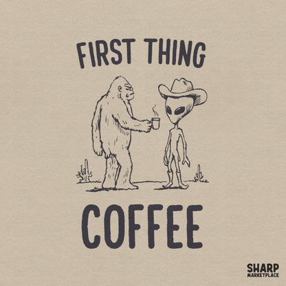 Hand-drawn sketch of a furry cryptid offering a steaming coffee mug to an alien wearing a cowboy hat and boots in a desert, with First Thing Coffee text.