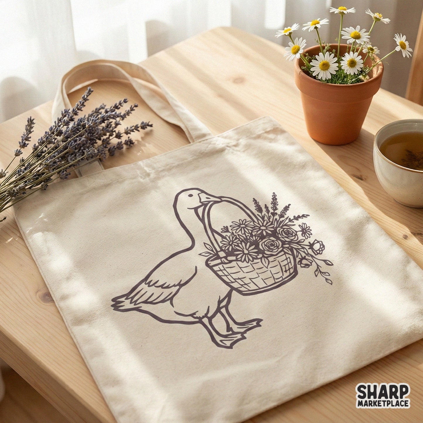 A charcoal-toned illustration of a farm goose holding a floral basket, showcased as a digital design for sublimation, stickers, or custom t-shirts.