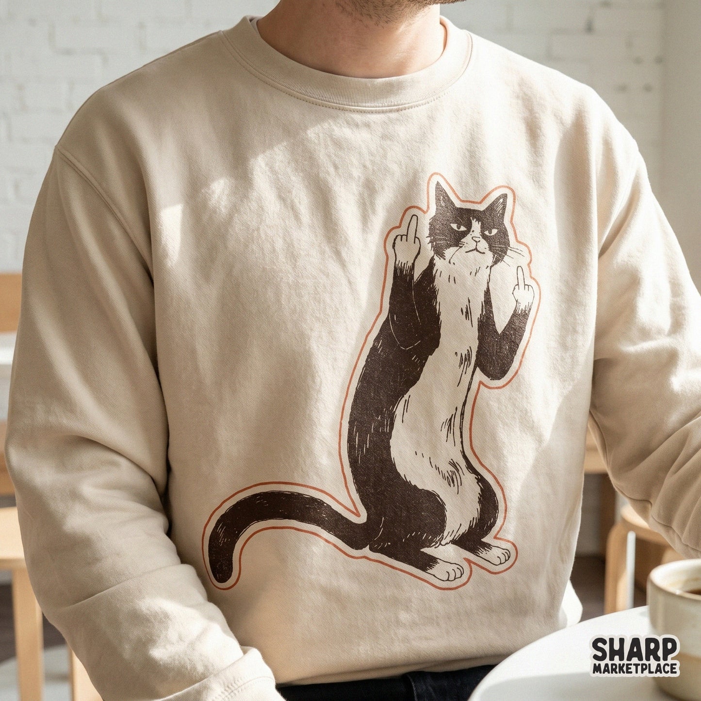A beige sweatshirt featuring a sarcastic tuxedo cat design with a grumpy expression and middle claws raised, perfect for funny apparel printing.