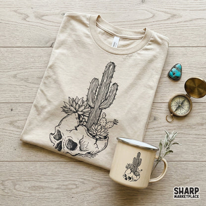 Monochromatic botanical skull graphic with a saguaro cactus and succulents, ideal for DIY western-themed projects and print-on-demand designs.