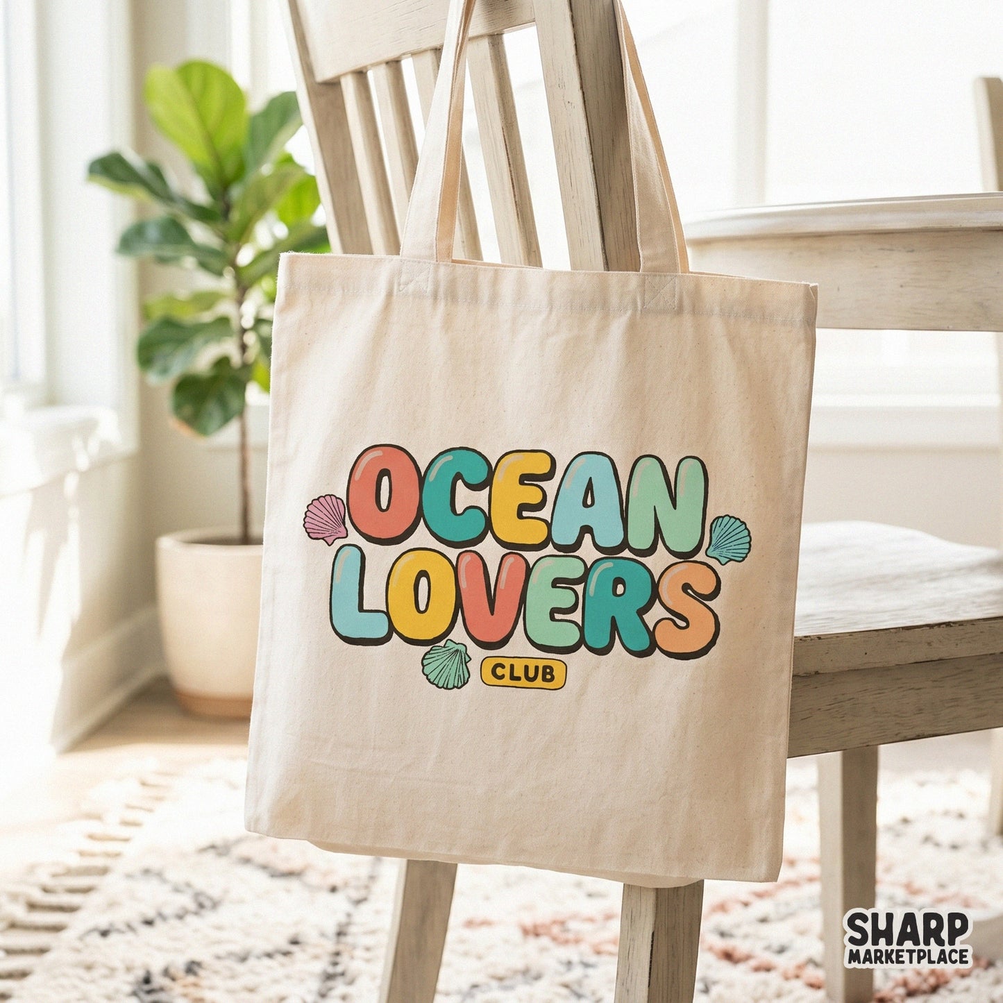 Digital design featuring Ocean Lovers Club text in a playful rounded font with shell accents, displayed on a canvas tote bag for beach-themed merchandise.