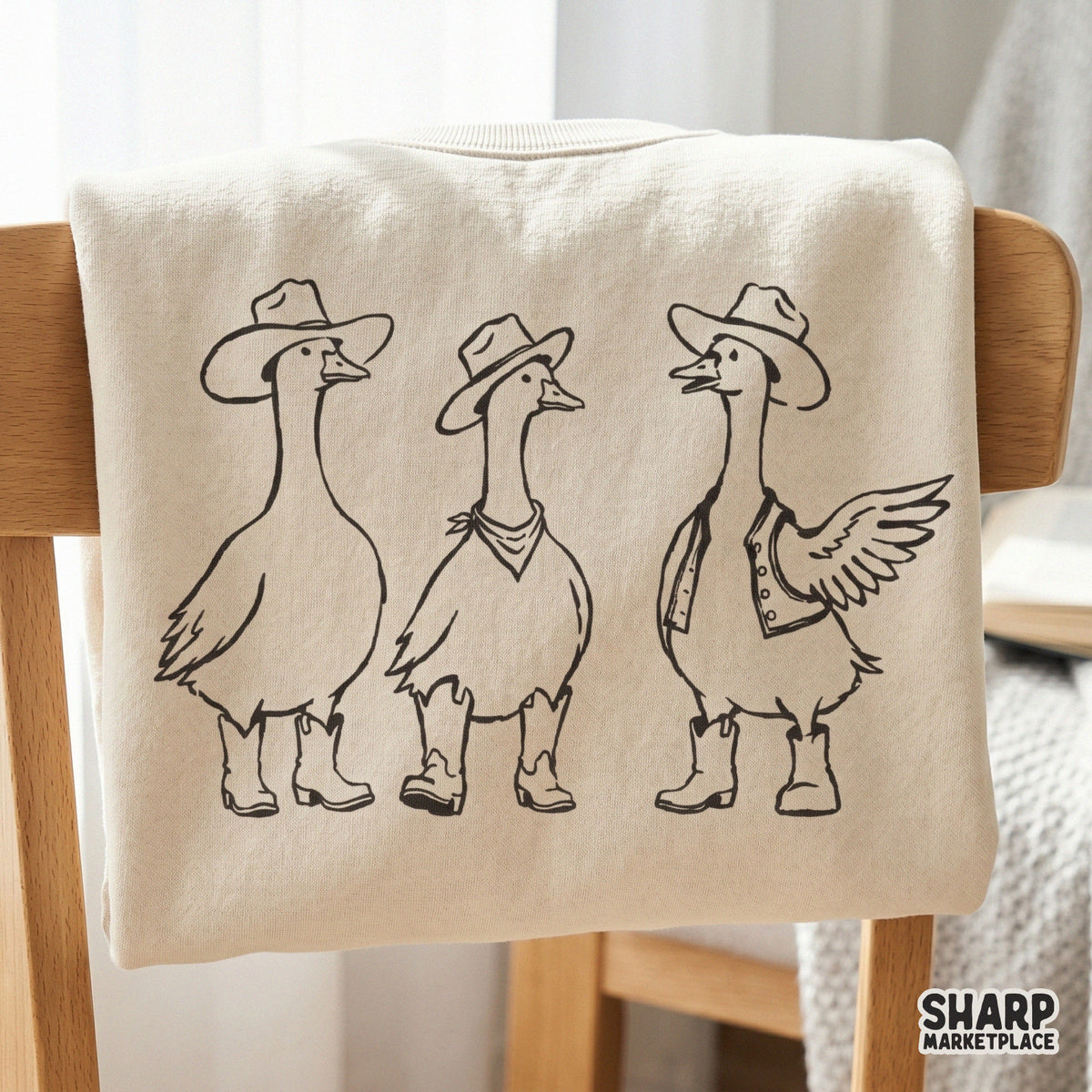 Vintage-inspired illustration of a silly goose trio in western attire, featuring cowboy hats, a bandana, and a vest, printed on a neutral shirt.