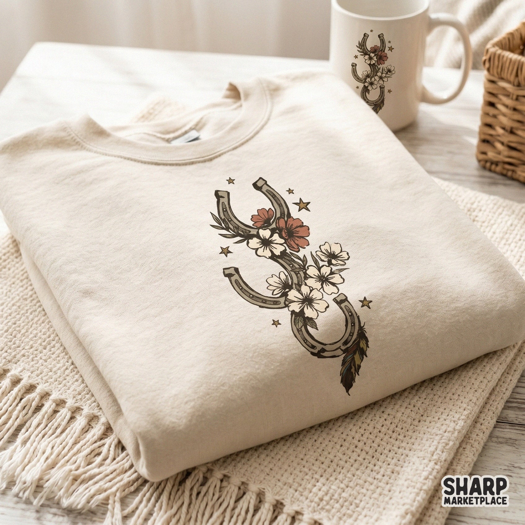 Digital design of three weathered horseshoes intertwined with cream and coral wildflowers and a feather, perfect for custom t-shirt printing.