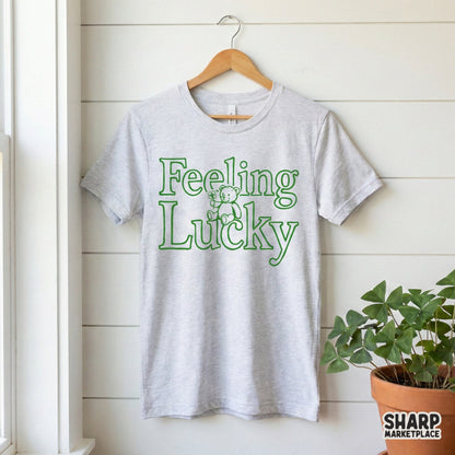 Cute green outline teddy bear holding a four-leaf clover with retro typography for holiday-themed DIY projects, apparel, and printable crafts.