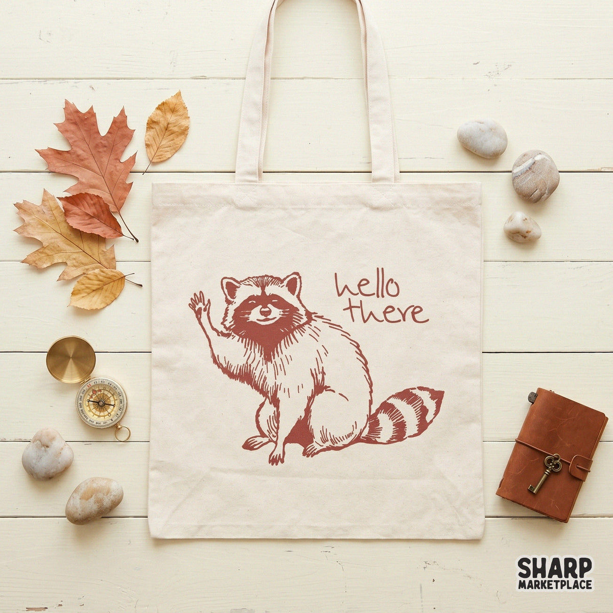 Digital download graphic of a friendly raccoon waving hello in a rustic maroon ink style, suitable for t-shirt printing and DIY crafts.