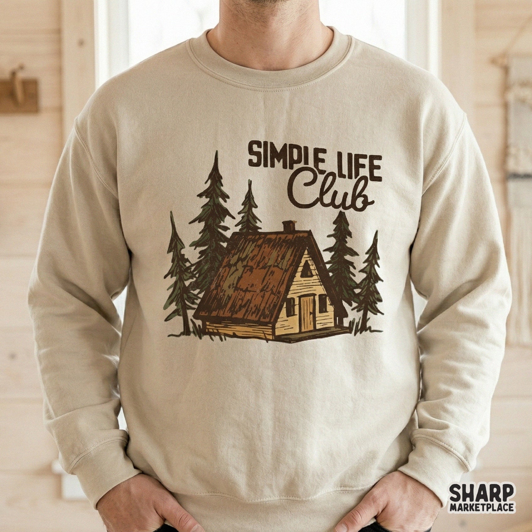 Digital woodland graphic with a hand-drawn A-frame cabin and pine trees, perfect for custom t-shirt printing, stickers, or nature-themed apparel projects.
