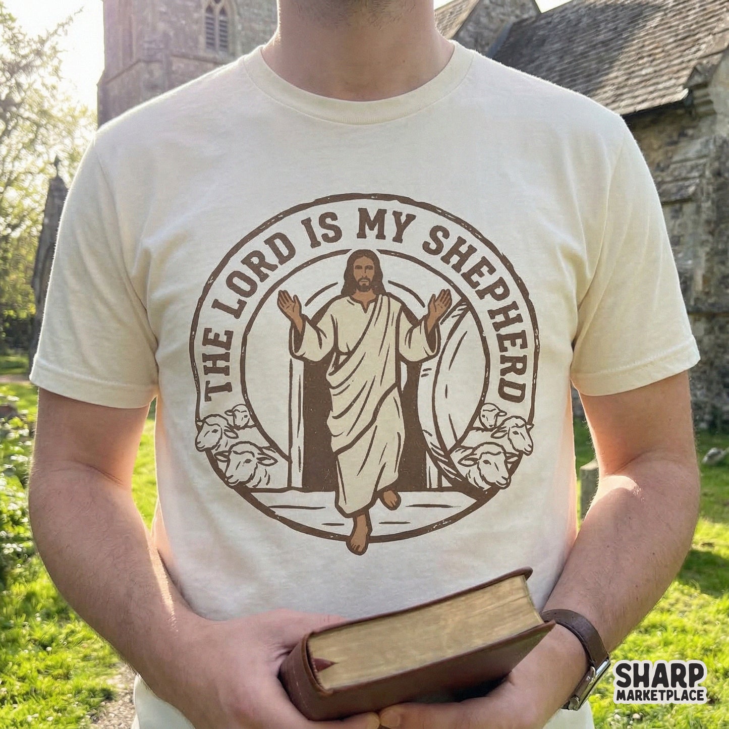 Brown monochromatic Christian graphic on a t-shirt showing Jesus and sheep in a circular frame, perfect for faith-based apparel and sublimation.