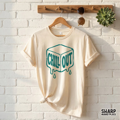 A cream colored t-shirt featuring a teal melting ice cube design with the words Chill Out in a playful, retro bubble font for summer projects.