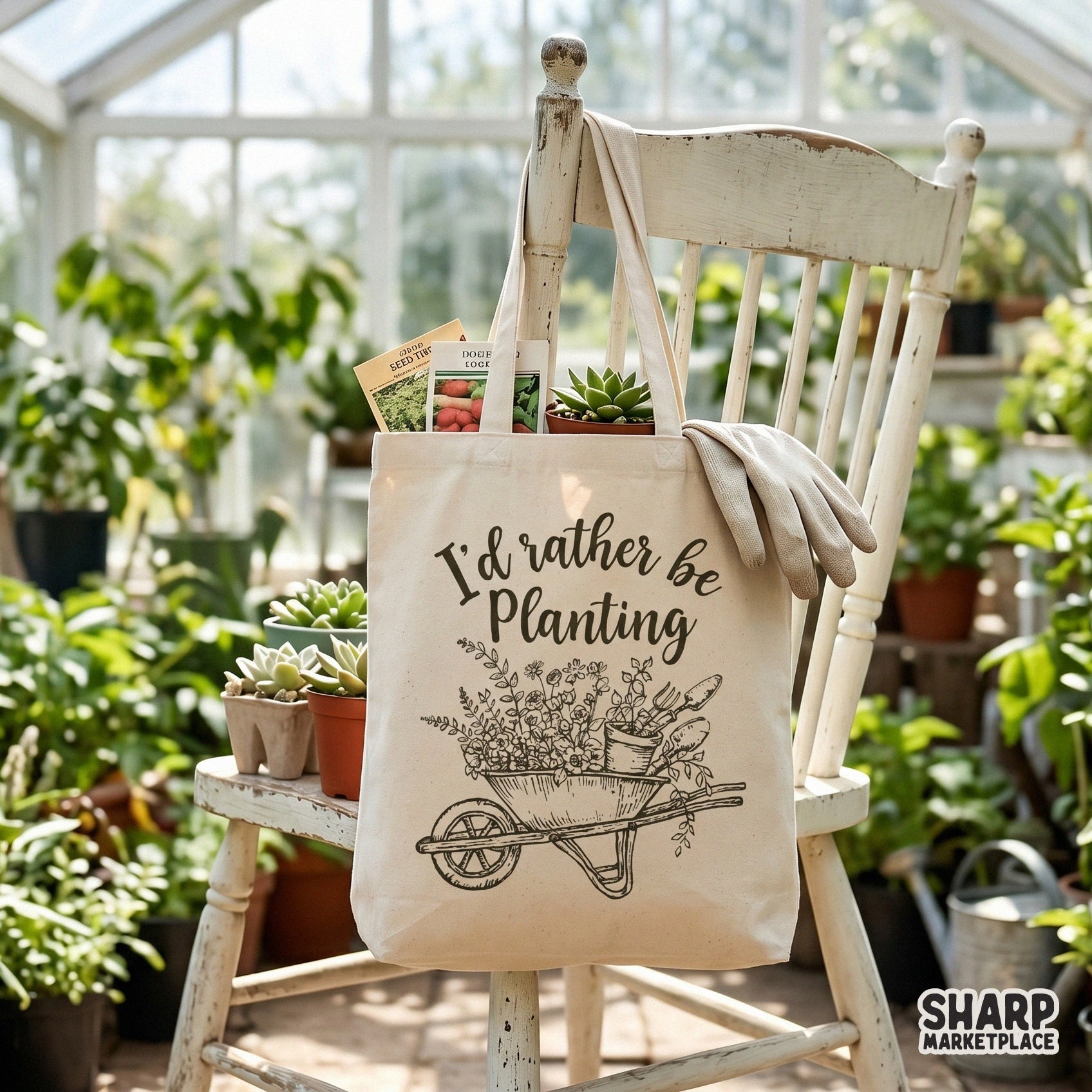 A canvas tote bag featuring a rustic brown sketch of a floral-filled garden wheelbarrow and the quote I'd rather be planting.