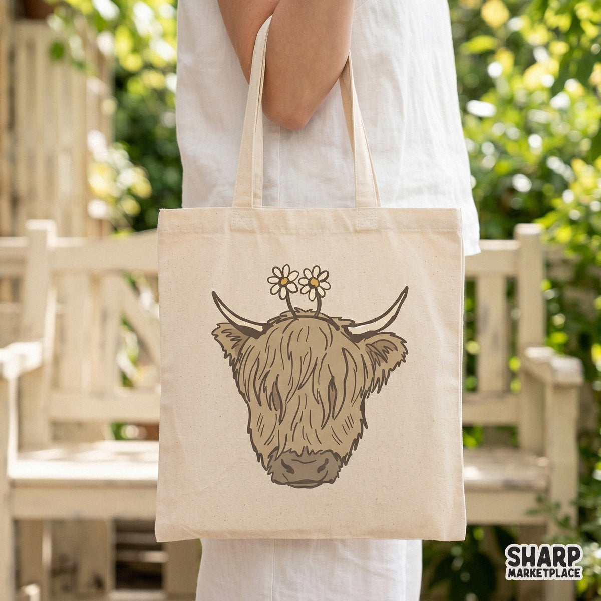 Rustic shaggy highland cow digital graphic with daisy accents, displayed on a neutral tote bag mockup for farmhouse or spring apparel projects.