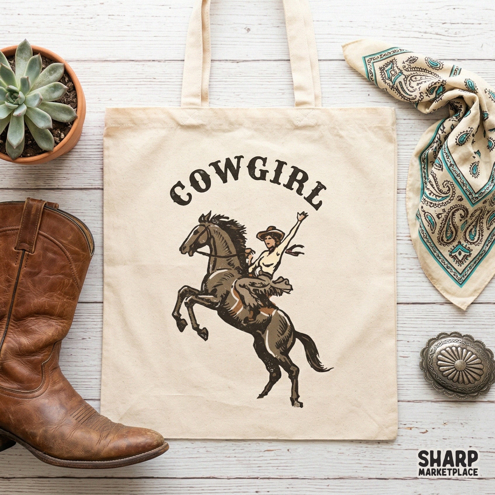 Trendy western apparel design featuring a cowgirl on a rearing horse with arched typography, displayed as a digital graphic on a canvas tote bag.