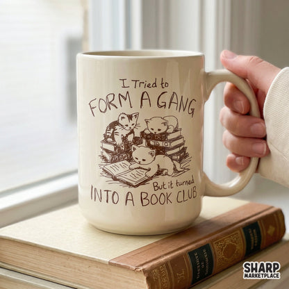 Retro-inspired digital graphic of kittens with open books, featuring the quote I Tried To Form A Gang But It Turned Into A Book Club in hand-lettered text.