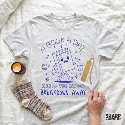 Whimsical hand-drawn book character design in blue ink featuring the quote A Book A Day Keeps The Mental Breakdown Away for DIY craft projects.