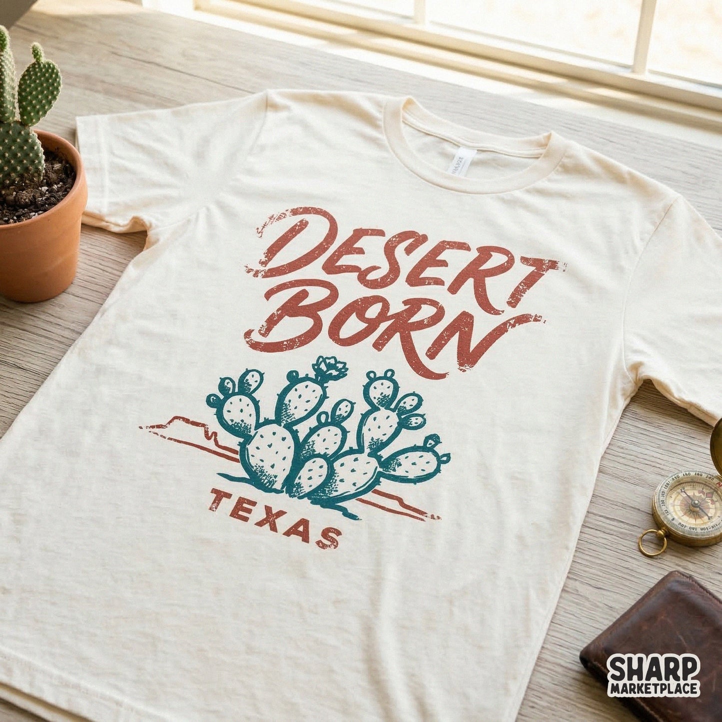 Vintage style Desert Born Texas graphic printed on a cream t-shirt showcasing a hand-drawn cactus and distressed typography for apparel.