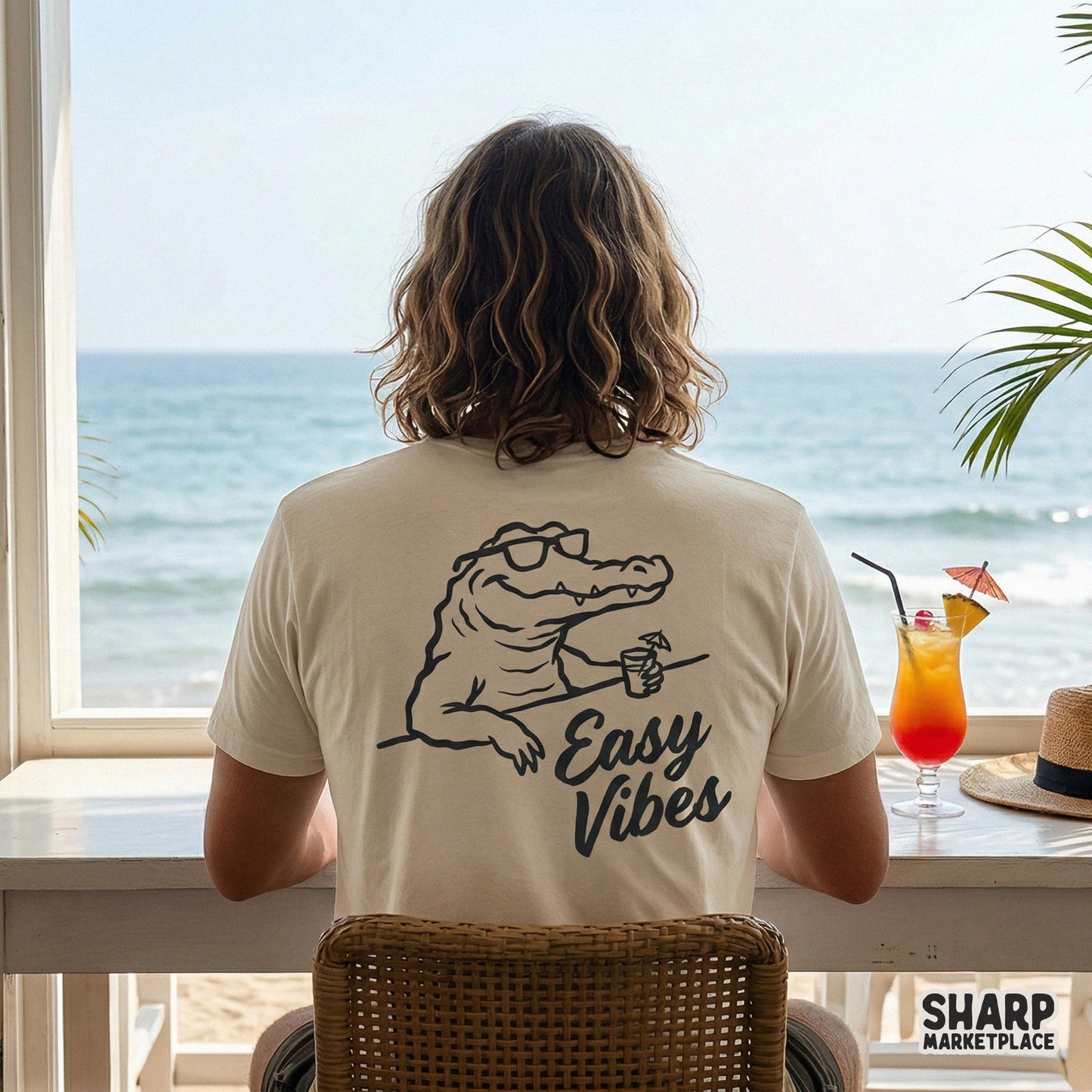Trendy summer sublimation design featuring a chill alligator in sunglasses with a cocktail and the words Easy Vibes, printed on a beige t-shirt.