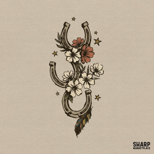 Western horseshoe illustration with wildflower charms, a feather trail, and stars in a rustic, vintage cowgirl style for sublimation and apparel.