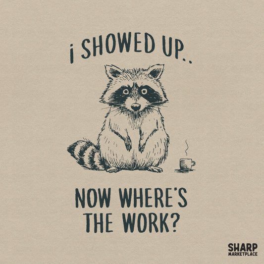 Hand-drawn sketch of a weary raccoon standing next to a steaming coffee cup with the text I Showed Up, Now Where's The Work? in distressed block letters.