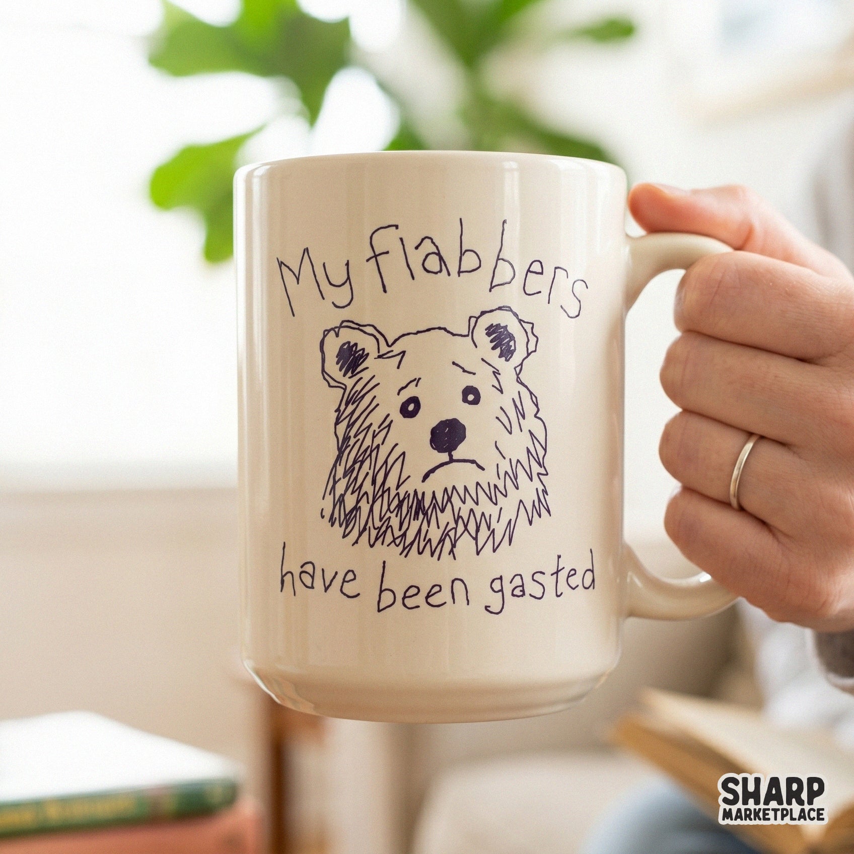 A ceramic mug featuring a hand-drawn purple sketch of a concerned bear and the humorous quote My Flabbers Have Been Gasted for trendy DIY apparel.