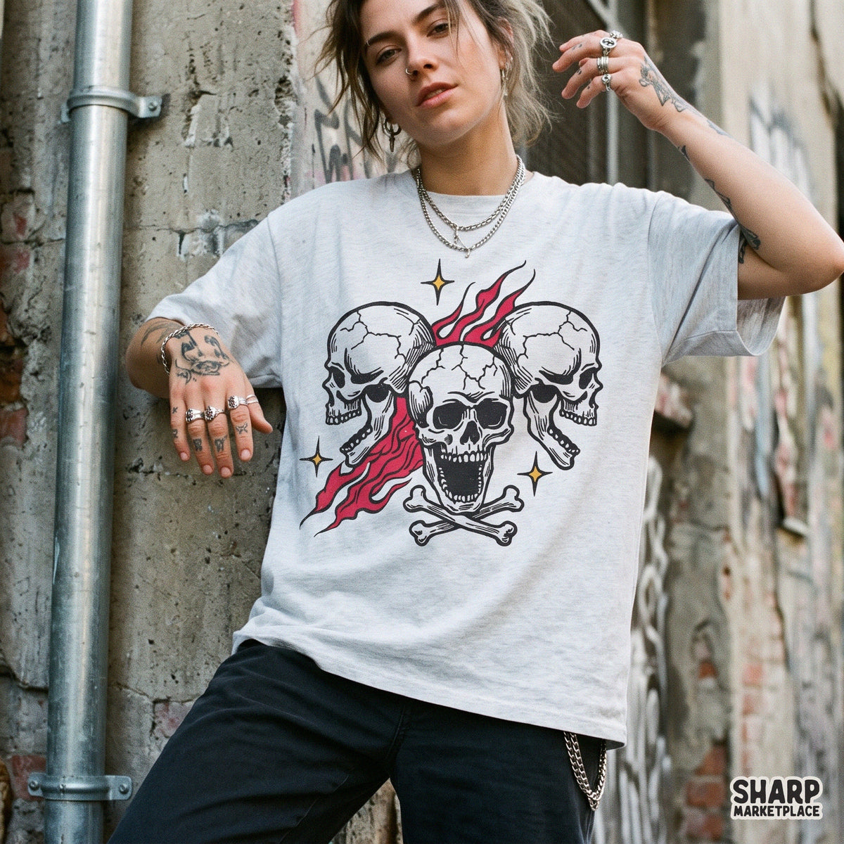 Three screaming skulls with burning red flames and crossbones, an edgy biker tattoo flash style Halloween PNG design