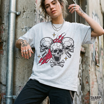 Three screaming skulls with burning red flames and crossbones, an edgy biker tattoo flash style Halloween PNG design