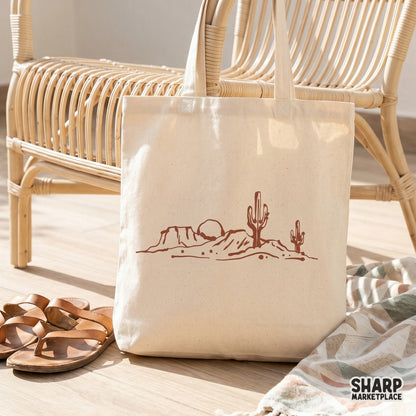 Boho western desert horizon graphic displayed on a canvas tote bag, featuring a simple line art mesa scene with cacti for sublimation projects.