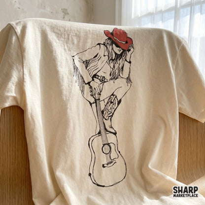 Cowgirl with a red hat and cowboy boots sitting on a guitar, a versatile western digital file for stickers, tumblers, and rodeo apparel.
