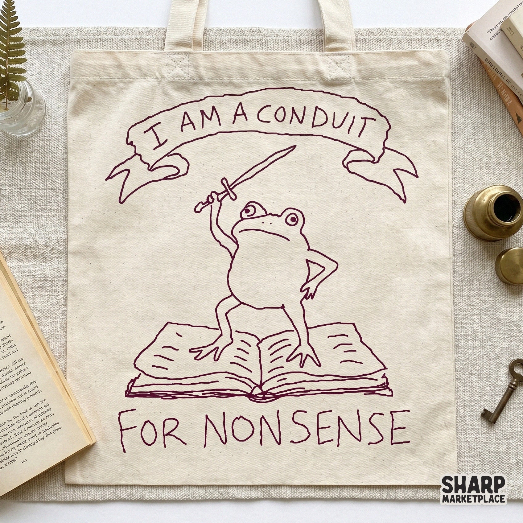 Whimsical digital illustration of a frog holding a sword atop an open book, accented with gold stars and the text I Am A Conduit For Nonsense.