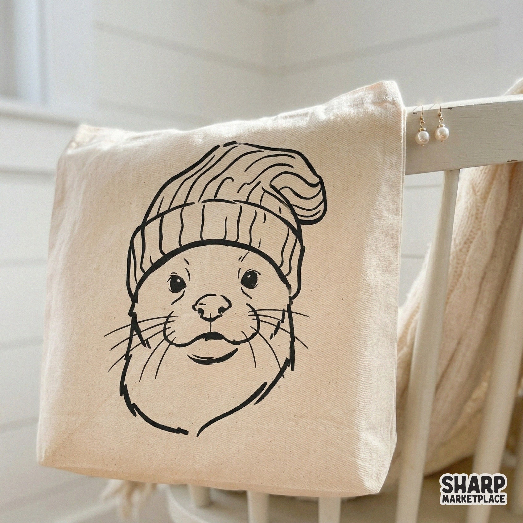 Digital illustration of a friendly otter face with whiskers and a textured winter beanie, designed for versatile use in print-on-demand and craft projects.