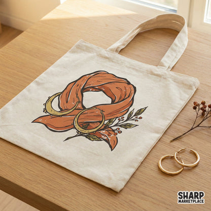 Boho orange scarf and crescent moon earring design printed on a canvas tote bag, showcasing a rustic, organic style for apparel customization.