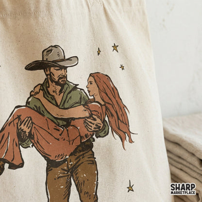Romantic cowboy carrying a woman through golden stars, featuring a distressed texture for trendy country-themed apparel and DIY craft projects.
