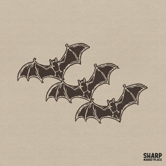 Vintage linocut style illustration featuring three flying bats for spooky season sublimation and halloween shirt designs