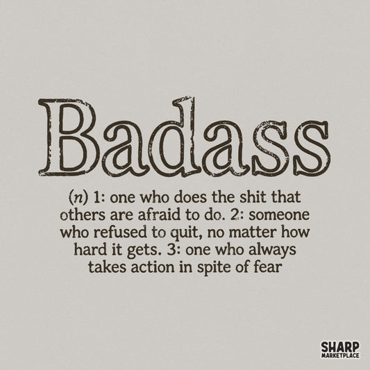 Distressed typewriter font typography defining the word Badass with three empowering meanings, presented as a clean black graphic on a light background.