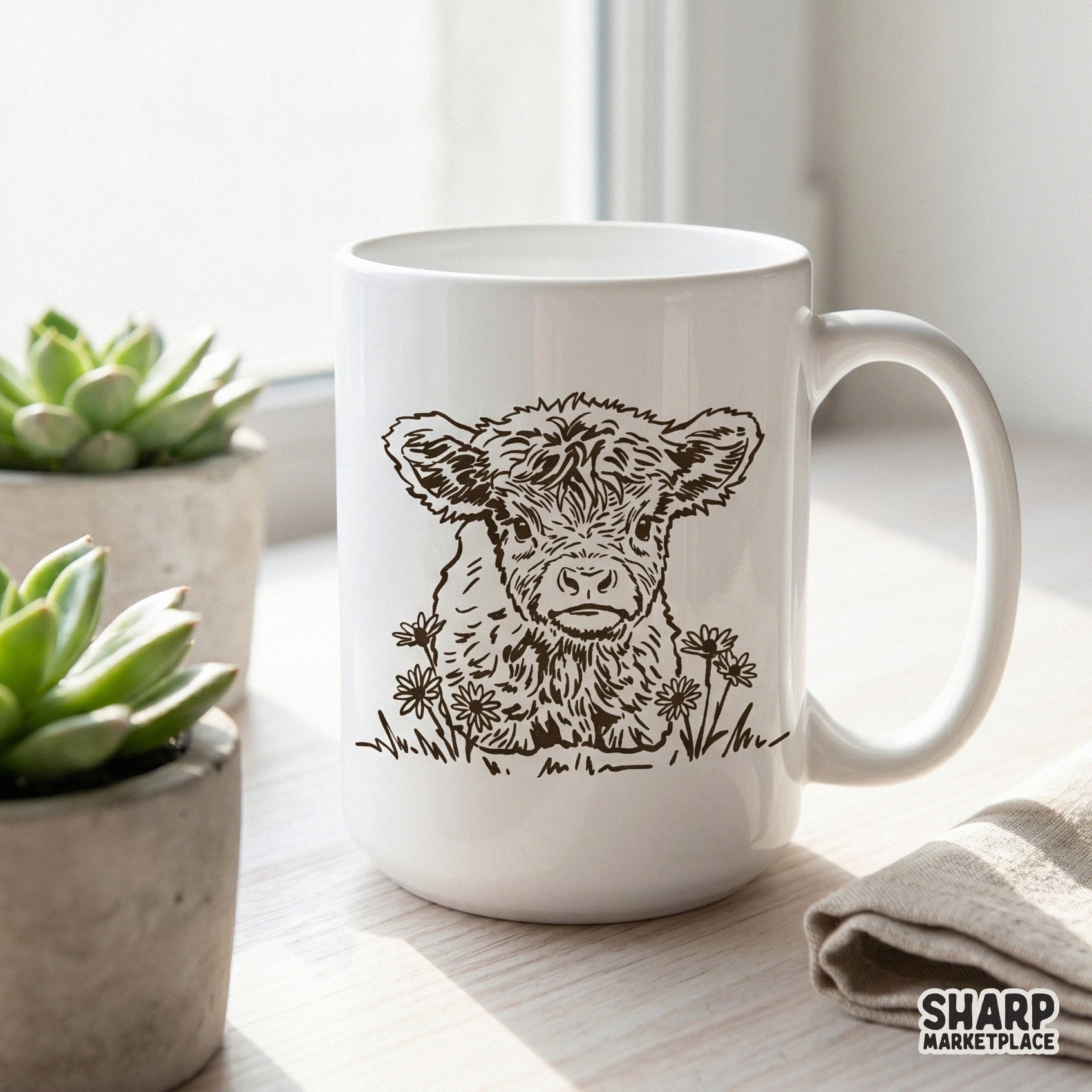 A white ceramic coffee mug featuring a rustic brown ink sketch of a cute baby calf surrounded by spring daisies for a farmhouse aesthetic.